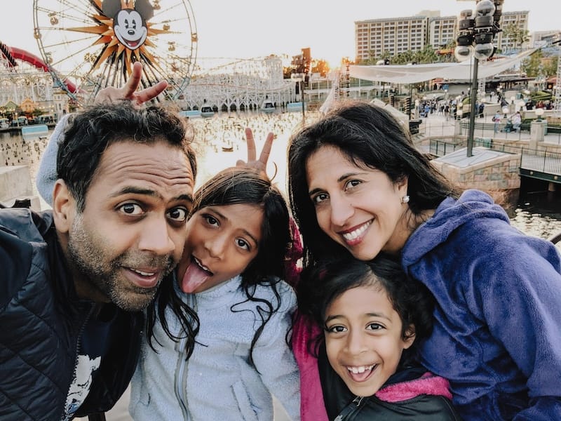 Raj and Monica with their daughters at an amusement park